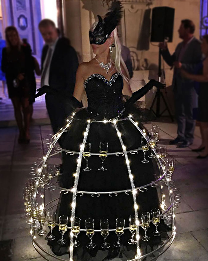 Porteuse de champagne en robe noire chic et brillante