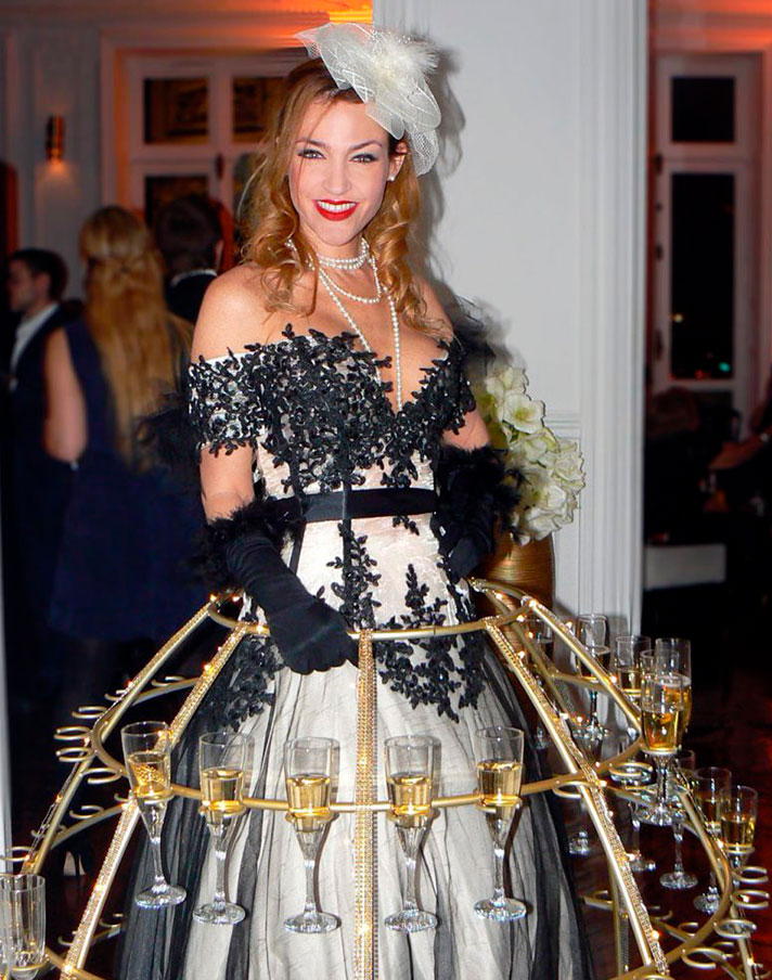 Porteuse de champagne en robe cocktail tenant des flûtes