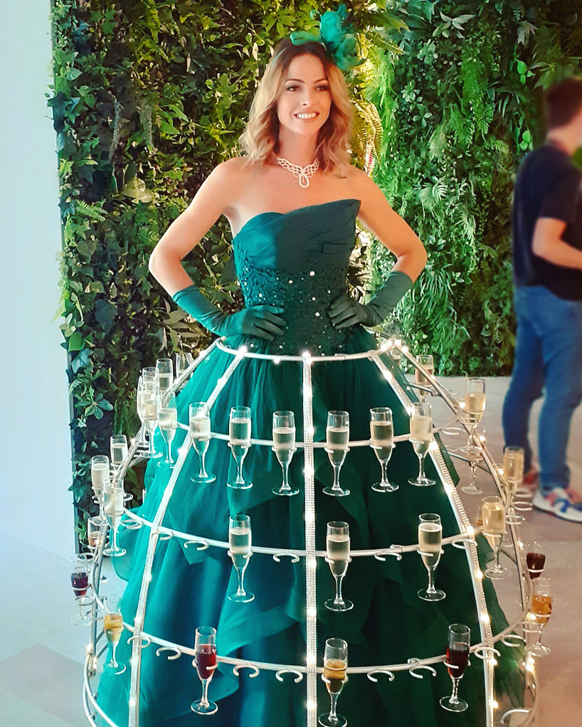 Porteuse de champagne en robe verte pour une ambiance végétale