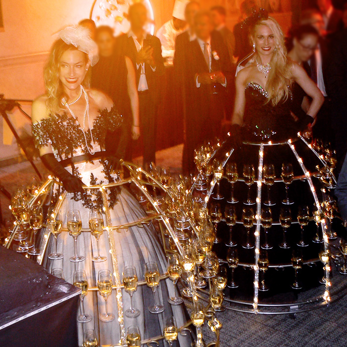 Hôtesses en tenue lumineuse servant le champagne lors d’un événement prestigieux